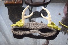 a crocheted mask with antlers on it sitting on top of a table