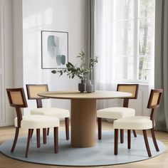 a dining room table with four chairs and a rug on the floor in front of it