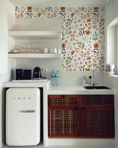 a kitchen with white walls and wooden cabinets