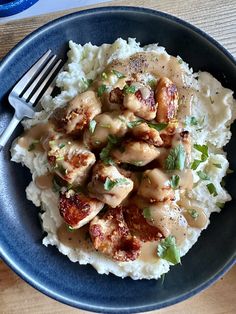 a blue plate topped with mashed potatoes and chicken