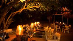 an outdoor dining area with candles lit on the tables