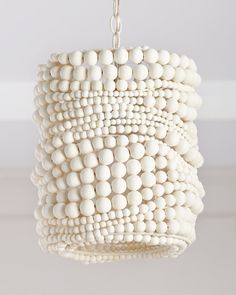 a chandelier made out of white beads hanging from a ceiling fixture in a room