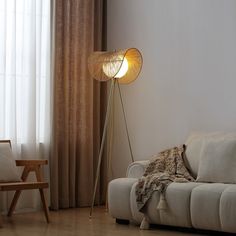 a living room scene with focus on the floor lamp and sofa in the foreground