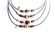 Rope choker necklace for men made of brown agate stone beads, wooden and bronze metal beads on dark brown leather cord, lobster clasp closure. Beaded leather cord choker will be a nice gift for him. Necklace length (adjustable): 17-19 inches (43-48 cm) Agate stone beads: 10 mm Wooden beads: 10 x 4 mm, 3 mm For all products are used only genuine high-quality Italian leather, natural stones and wood. All metal materials are lead and nickel free. /Gift wrapping and packaging/ : All items ordered wi Surfer Jewelry, Cord Choker, Brown Agate, Leather Cord Necklace, Brown Stone, Leather Corded Necklace, Jewelry Care Instructions, Leather Chokers, Bronze Metal