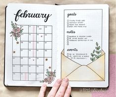 a hand is holding an open planner with flowers on it and the calendar has been opened