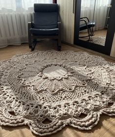 a large crocheted doily sits on the floor in front of a mirror