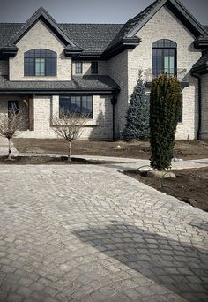 a large brick driveway in front of a house