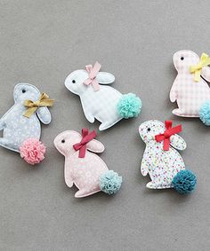 several small stuffed animals sitting next to each other on a gray surface with polka dots