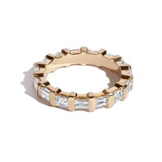 an 18k gold band with baguettes and diamonds, set on top of a white background