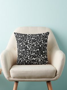 a black and white pillow sitting on top of a chair