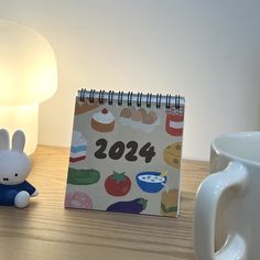 a desk with a calendar and a small rabbit figurine sitting next to it