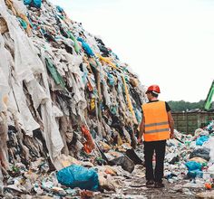 a man standing in front of a pile of garbage