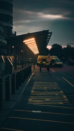 an ambulance parked in front of a building with its lights turned on at night time