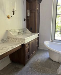 a bathroom with marble counter tops and wooden cabinets