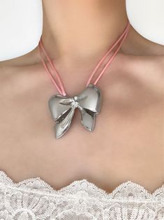 An accessory this irresistible is hard to come by. Meet the 'JENNIE' necklace - featuring our exclusive pink satin cord and a precious bow pendant, you'll never want to take this piece off! Made with genuine satin cord and stainless steel pendant. Waterproof & rust-free. Available in lengths 14", 15", 16", 18". All lengths include a 2" extension chain. Model is wearing 15". Handmade with love in Los Angeles. Silver Jewelry With Satin Bow For Party, Silver Party Jewelry With Satin Bow, Pink Bow Necklace For Party, Gift Jewelry With Pink Bow, Elegant Adjustable Jewelry With Pink Bow, Adjustable Necklace With Decorative Bow, Silver Jewelry With Satin Bow As Gift, Silver Jewelry With Satin Bow For Gifts, Adjustable Silver Necklace With Ribbon