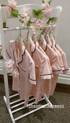 five pink shirts hanging on a rack with flowers in them and the words, there is no image here to provide a caption for