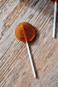 two lollipops sitting next to each other on top of a wooden table