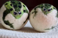 two green and white balls with faces on them