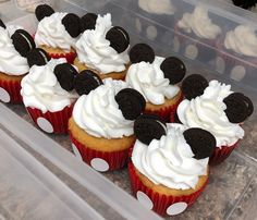 some cupcakes with white frosting and mickey mouse ears on them in a plastic container