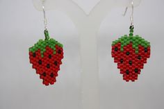 a pair of earrings made out of legos with fruit on the front and back