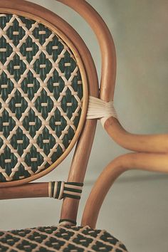 a close up of a wooden chair with a woven seat pad on the back of it