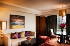 a living room filled with furniture next to a window covered in curtains and drapes