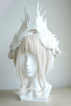 a mannequin head with white feathers on it