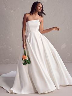 a woman in a white wedding dress with flowers on her hand and wearing a flower bouquet