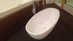 a large white bath tub sitting on top of a bathroom floor