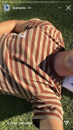 a man laying on top of a lush green field