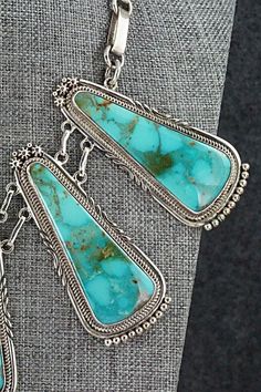 This vintage and intricately crafted Turquoise Mountain turquoise and sterling silver necklace, earrings, bracelet and ring set was made by Navajo silversmith Oliver Smith. The set is signed O. Smith and stamped .925.Necklace: 18"Length: 2 5/8"Width: 1 1/8"Earrings:Length: 1 3/8"Width: 3/4"Ring:Size: 10.5Length: 1 1/4"Width: 1"Bracelet:Size: 5 1/4" (fit for a 6 3/4" wrist)Gap: 1 1/2"Length: 1 3/4"Free shipping on all orders! We ship with USPS and always include tracking. All orders ship within a One Of A Kind Southwestern Turquoise Jewelry, One-of-a-kind Southwestern Turquoise Jewelry, Artisan Untreated Jewelry For Collectors, Southwestern Style Jewelry In Sterling Silver Stamped 925, Southwestern Style Jewelry In Sterling Silver, Southwestern Sterling Silver Jewelry Stamped 925, Southwestern Sterling Silver Hallmarked Jewelry, Southwestern Style Turquoise Jewelry In Sterling Silver, Southwestern Hallmarked Sterling Silver Jewelry