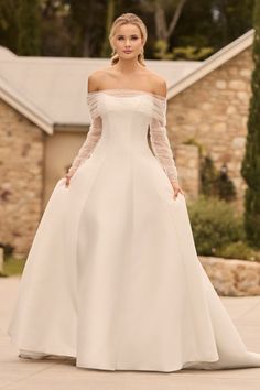 a woman in a white wedding dress standing outside