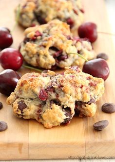 three cookies with cherries and chocolate chips on a cutting board