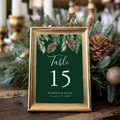 a table number sign with pine cones and evergreen leaves