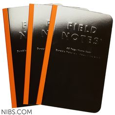 three black notebooks with neon orange bands on each side and the words field notes written in white