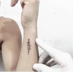 a woman's arm with a small tattoo on the left side of her wrist