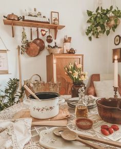 a table topped with lots of dishes and utensils next to a potted plant