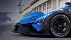 a blue sports car parked in front of a building