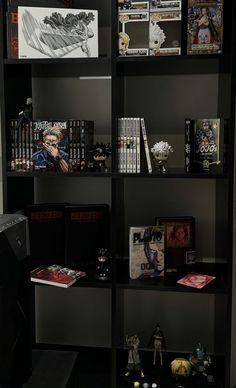 a book shelf filled with lots of books and comics on top of black shelving