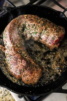 some meat is cooking in a skillet on the stove