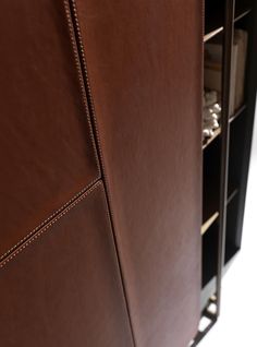 a brown leather cabinet with shelves and drawers