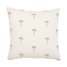 a white pillow with gold palm trees printed on the front and back, sitting against a white background