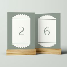 two folded cards with the number six on them, sitting next to each other in front of a gray background