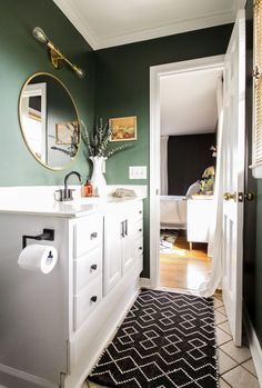 a bathroom with green walls and white cabinets