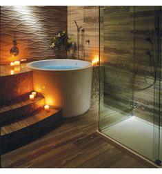 a bathroom with candles on the floor and a bathtub in the middle of it