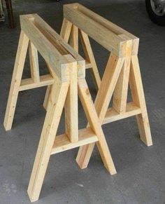 two wooden stools sitting next to each other on the ground in front of a car