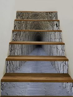 a set of steps leading up to a tunnel with stone walls and wood handrails