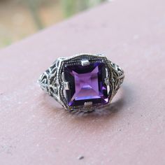 Vintage Sterling Silver Princess cut Amethyst Filigree Ring ...Marked 925...Total of weights 3.4grams...Size 8...Measure of Face 12.9MM...It's in very good condition. Purple Sterling Silver Diamond Cut Jewelry, Purple Sterling Silver Jewelry Diamond Cut, Purple Diamond Cut Sterling Silver Jewelry, Classic Purple Ring As Gift, Classic Purple Rings As Gift, Art Deco Purple Amethyst Ring For Anniversary, Purple Amethyst Art Deco Ring For Anniversary, Purple Sterling Silver Filigree Jewelry, Classic Purple Gemstone Birthstone Ring