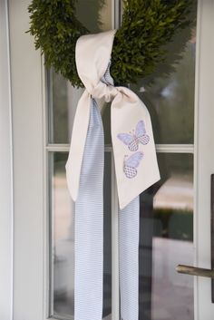 a white door with a wreath and ribbon on it