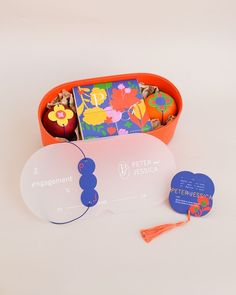 an orange box filled with assorted children's books next to a pair of scissors